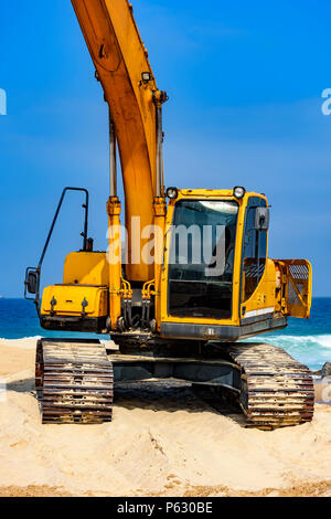 Cabine pelle jaune et le bras sur le sable à plage dans une journée ensoleillée Banque D'Images