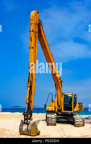 Cabine pelle jaune et le bras sur le sable à plage dans une journée ensoleillée Banque D'Images