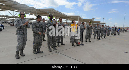 Les membres de la 61e Unité de maintenance d'aéronefs cheers leur équipe au cours de l'équipe de chargement trimestriel compétition à Luke Air Force Base, en Arizona, le 8 avril 2016. La compétition les deux équipes de F-16 Fighting Falcon de l'équipe de chargement d'aviateurs et de maintenance d'aéronefs 310e 309e, et une équipe de la 149e uma hors de Lackland Air Force Base. En outre, une équipe de F-35 Lightning II équipe de chargement d'aviateurs à partir de la 61e UMA a aussi participé. (U.S. Photo de l'Armée de l'air par la Haute Airman Devante Williams) Banque D'Images