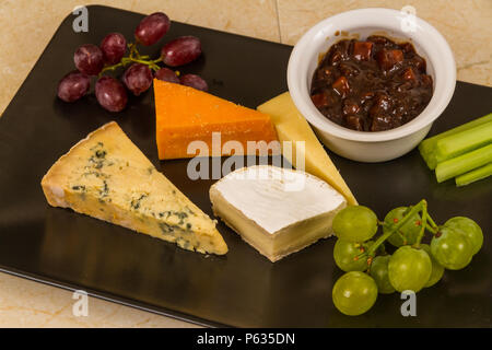 Plateau de fromages, du plateau, du fromage, red leicester, stilton, cheddar, le camembert, le raisin, le céleri, le cornichon ou chutney. Banque D'Images