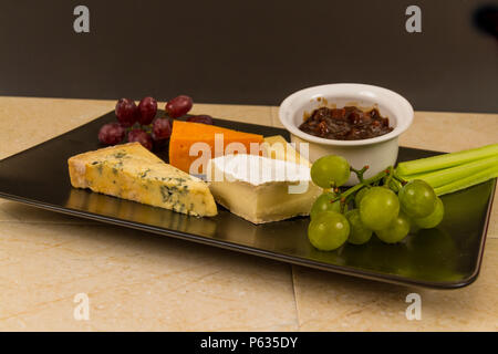 Plateau de fromages, du plateau, du fromage, red leicester, stilton, cheddar, le camembert, le raisin, le céleri, le cornichon ou chutney. Banque D'Images