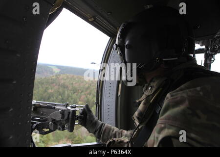 Un soldat américain de la Compagnie Charlie, 3e Bataillon, 227e Régiment d'aviation 'Spearhead' fournit la sécurité pour un UH-60 Black Hawk tout en menant des opérations de charge sabre au cours de l'exercice à la sortie 16 de l'armée américaine multinationale interarmées (Centre de préparation) JMRC en Hohenfels, Allemagne, le 13 avril 2016. Sortie 16 Sabre de l'armée américaine est la 173e Brigade aéroportée de l'Europe centre de formation de combat de l'exercice de certification, qui aura lieu à l'JMRC en Hohenfels, Allemagne, Mars 31-avr. 24, 2016. L'exercice est conçu pour évaluer le niveau de préparation de l'Armée de l'Europe de brigades de combat Banque D'Images