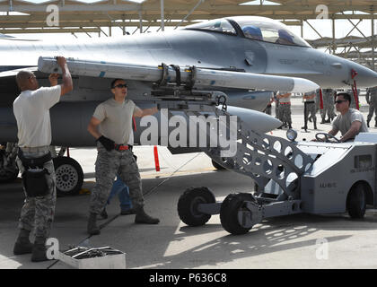 Tech. Le Sgt. Mark Nash (à gauche), Tech. Le Sgt. Federico Barrios (centre) et les cadres supérieurs Airman Robert Satter (à droite), les techniciens de systèmes d'armement des avions, chargez une matière inerte, AIM-120 à moyenne portée avancée air-air sur l'aile d'un F-16 Fighting Falcon durant la partie chargement de la 56e Escadre de chasse de charge trimestriel de l'équipage du trimestre la concurrence à Luke Air Force Base, Texas, le 8 avril 2016. Nash, Barrios et Satter sont membres de la Garde nationale aérienne du Texas's 149th Fighter Wing, basé à Joint Base San Antonio-Lackland, Texas, qui est actuellement exploité à Luke tout en un SAN Banque D'Images