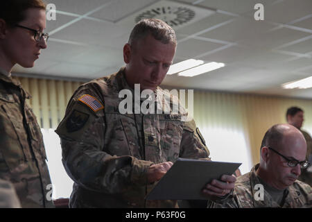 Un soldat américain du 18e Bataillon de soutien logistique du combat se lit un exposé pour les soldats sur les événements de rotation de jonction Sabre 2016 tout en menant une analyse après action Sabre au cours de l'exercice à la sortie 16 de l'armée américaine multinationale interarmées (Centre de préparation) JMRC en Hohenfels, Allemagne, le 20 avril 2016. Sortie 16 Sabre de l'armée américaine est la 173e Brigade aéroportée de l'Europe centre de formation de combat de l'exercice de certification, qui aura lieu à l'JMRC en Hohenfels, Allemagne, Mars 31-avr. 24, 2016. L'exercice est conçu pour évaluer le niveau de préparation de l'Armée de l'Europe pour mener des brigades de combat Banque D'Images