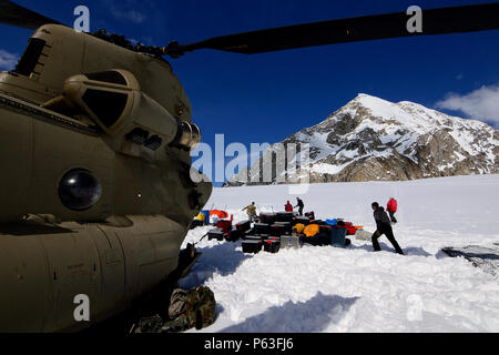 Le personnel du Service des parcs nationaux et des soldats de la Compagnie B, 1er Bataillon, 52e Régiment d'Aviation à décharger du matériel et des fournitures à partir d'un hélicoptère CH-47F Chinook après l'atterrissage sur le Glacier Kahiltna. Trois équipages de l'aviation en Alaska l'armée américaine Groupe d'étude a passé la semaine à Talkeetna, Alaska, la formation en haute altitude de vol dans la chaîne de l'Alaska. La mission pour le dimanche, 24 Avril inclus poursuivent un partenariat de longue date avec le National Park Service navette pour le matériel et les fournitures nécessaires pour le Service des parcs camp de base sur le Glacier Kahiltna pour la prochaine saison d'escalade sur Denali. (Armée de ph Banque D'Images