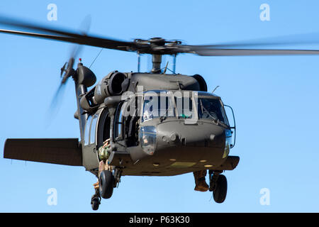 Un UH-60 Blackhawk de l'armée américaine vole vers Victory Pond à Fort Benning, en Géorgie, le 17 avril 2016, pour des opérations d'helocast lors de la 33e compétition annuelle du meilleur Ranger. L'événement s'étend sur trois jours et teste les compétences physiques, mentales et techniques à travers des parcours d'obstacles, des missions aéroportées et des exercices tactiques. L’aviation de l’armée de terre et la Brigade d’entraînement aéroportée et des Rangers fournissent un soutien, démontrant l’utilité de l’UH-60 pour l’insertion rapide de troupes, les opérations sur le terrain et la coordination avec les concurrents des Rangers. Banque D'Images