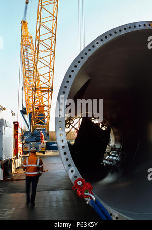 Décharger les travailleurs de grandes sections de tubes que forme le corps d'un géant d'éoliennes Enercon. Worksop Royaume-uni. Décembre 2008. Banque D'Images