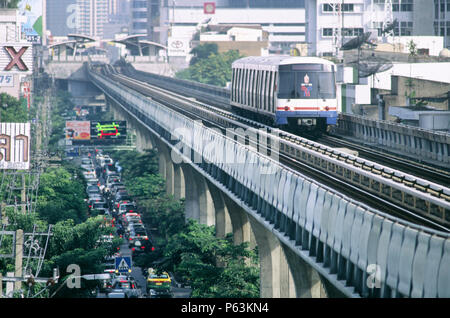 Skytrain de Bangkok s'exécutant sur sa voie en béton surélevé au-dessus de la circulation sur la route principale Sukhumvit loin de la station de métro aérien Phrom Phong, Bangkok, Thaïlande Banque D'Images