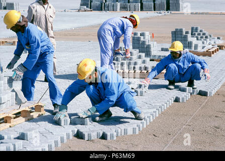 Les travailleurs de la construction du bloc de pose de pavage, d'empilage de conteneurs du port de DUBAÏ, ÉMIRATS ARABES UNIS Jebel Ali. Banque D'Images