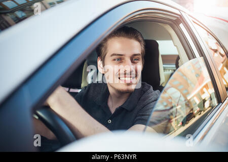 Profitez de la route. Image de jeune beau mec assis en voiture. Banque D'Images