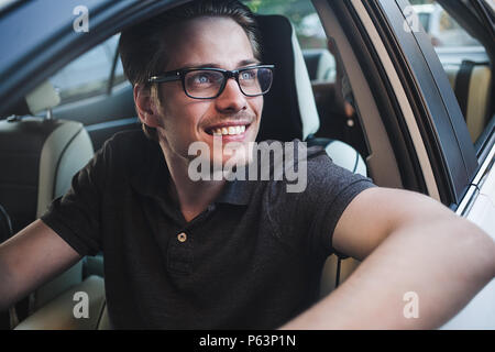 Profitez de la route. Image de jeune beau mec assis en voiture. Banque D'Images