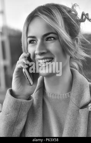 Cute smiling young woman talking on phone debout sur la mariée. Close up portrait Banque D'Images