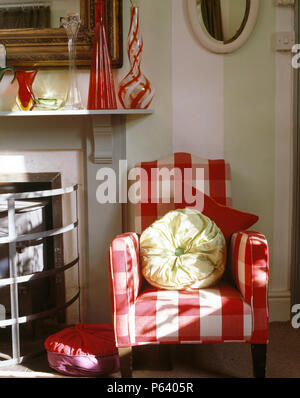 Blanc-rouge +grand fauteuil vérifié à côté de cheminée dans countrysitting prix Banque D'Images