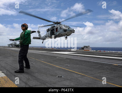 180625-N-H193-0054 de l'OCÉAN PACIFIQUE (25 juin 2018) l'Aviation 3e classe Mécanicien structurels Lucas Harney ordonne à l'équipage d'un MH-60S Sea Hawk affecté à la "Black Knights" de l'Escadron d'hélicoptères de combat de la mer (HSC) 4 au cours d'un ravitaillement en mer à bord de la classe Nimitz porte-avions USS Carl Vinson (CVN 70). (U.S. Photo par marine Spécialiste de la communication de masse 3 classe Alexander C. Kubitza/libérés) Banque D'Images