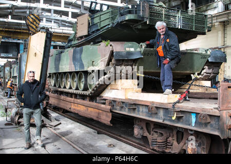 Les travailleurs du rail guide d'un wagon portant un M1A2 char de combat principal dans un entrepôt lors d'une opération de port le 1 mai 2015 dans le port de Varna, Bulgarie. Au cours de l'opération, les travailleurs ont changé les camions de wagons transportant de l'équipement devant être utilisé par les soldats du 1er Bataillon, 64e régiment de blindés, 1st Armored Brigade Combat Team, 3ème Division d'infanterie au cours de l'exercice Noble Partenaire peut 11-26 de Vaziani, Géorgie. (U.S. Photo de l'armée par le sergent. Michael Behlin) Banque D'Images