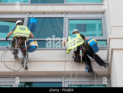 Nettoyage de vitres sur corde et poignées d'aspiration à l'extérieur une fenêtre de bureau Banque D'Images