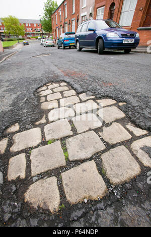 Vieille rue pavée, révélé en dessous sur un tarmac Oldham Street Lancashire UK Banque D'Images