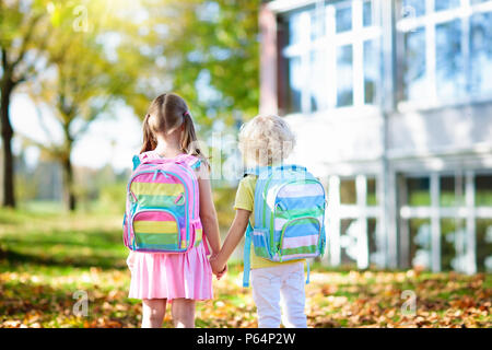 Les enfants retourner à l'école. Début de la nouvelle année scolaire après les vacances d'été. Garçon et fille avec sac à dos et des livres sur la première journée d'école. Début de cla Banque D'Images