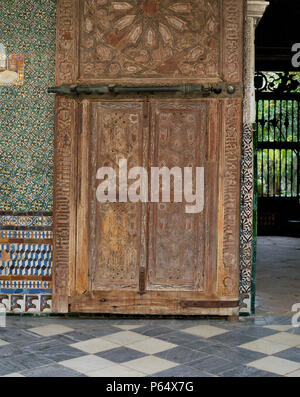 La sculpture artistique sur la vieille porte de bois avec des murs en mosaïque,Casa Pilatos,Sevilla, Espagne Banque D'Images