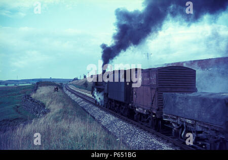 Un transport mixte Banque Shap monte derrière un British Railways Standard Class 9F 2-10-0 en septembre 1967. Banque D'Images