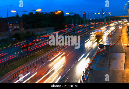 Les heures de pointe du soir au cours de travaux routiers. Le trafic sur l'autoroute M60, Manchester, Royaume-Uni. Banque D'Images