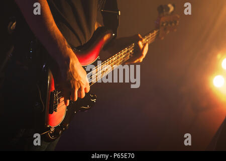 Le guitariste joue sur de la guitare basse dans la ville pittoresque de lumières, soft focus sélectif, musique live theme Banque D'Images