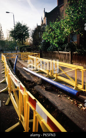 Barrière de sécurité en plastique autour d'une tranchée pour pose de canalisations d'eau pour les in Wandsworth, Londres, UK Banque D'Images