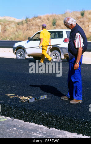 L'asphalte sur une nouvelle route. Contrôle de niveaux horizontaux sur nouvelle base d'asphalte d'une route près de Madrid en Espagne. Banque D'Images