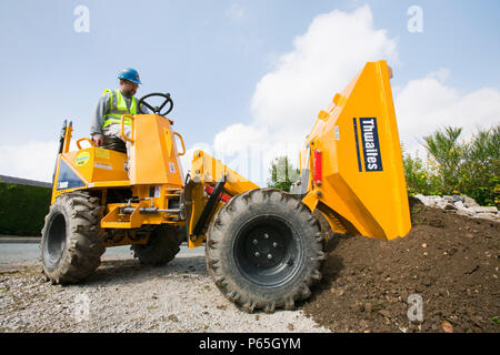 Un constructeur de conduire un camion dumper mini sur une maison, extension d'emploi bâtiment, Ambleside, Cumbria, Royaume-Uni. Banque D'Images