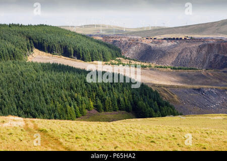 Le changement climatique le ciel et l'enfer, l'Hagshaw Hill wind farm au-dessus de la mine de charbon à ciel ouvert de Spireslack dans le Lanarkshire, Écosse, Royaume-Uni. Banque D'Images