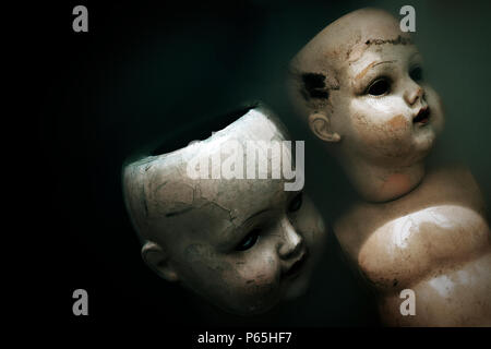 Creepy poupées dans l'eau sombre sale Banque D'Images