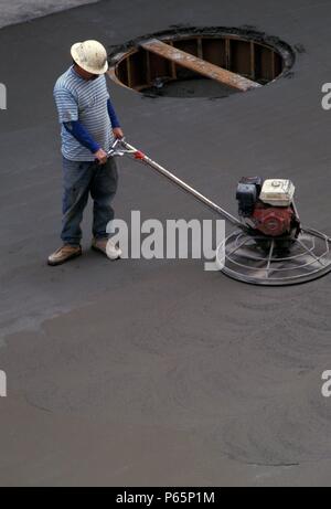 Sol en béton de finition à l'aide du module de finition d'alimentation Banque D'Images