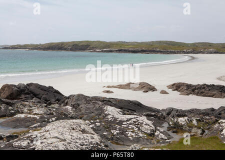 Un jeune couple à pied sur une plage de sable blanc immaculé et près de Ballyconneely dans le Connemara, comté de Galway, Irlande Banque D'Images