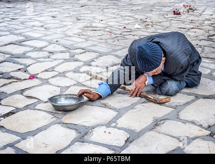 La Tunisie, Sousse. Mendiant sur la place de la vieille ville (médina) à l'enceinte de la Grande Mosquée. Banque D'Images