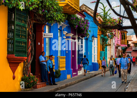 Les touristes à pied le long des maisons coloniales peintes de couleurs vives dans la rue située dans la ville fortifiée historique de Cartagena, Colombie. Banque D'Images