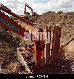 L'excavation de tranchée sur le marais d'Essex pour installer la tuyauterie d'alimentation en gaz pour l'Aboiement atteindre power station. De plus le tableau de bord pour les centrales au gaz Gaz Banque D'Images