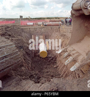 L'excavation de tranchée sur le marais d'Essex pour installer la tuyauterie d'alimentation en gaz pour l'Aboiement atteindre power station. De plus le tableau de bord pour les centrales au gaz Gaz Banque D'Images