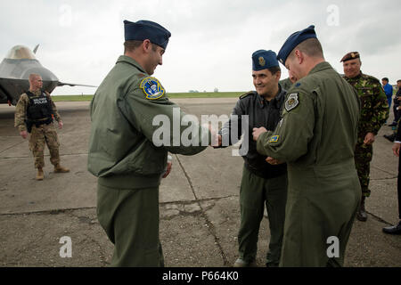 Le général de la Force aérienne roumaine Laurian Anastasof, centre, chef de la Force aérienne roumaine, le personnel se réunit avec les pilotes de chasse de l'US Air Force à l'avant d'un F-22 Affichage statique avant de tenir une conférence de presse avec les médias roumains Mihail Kognalniceanu à bord Air Base, la Roumanie, le 25 avril 2016. L'aéronef effectuera l'entraînement aérien avec d'autres aéronefs basé en Europe et sera également déployer avant d'Angleterre pour maximiser les possibilités de formation tout en démontrant l'engagement des États-Unis à l'OTAN et la sécurité de l'Europe. (U.S. Marine Corps photo par le Cpl. Kelly L. Street, 2D MARDIV COMCAM Banque D'Images