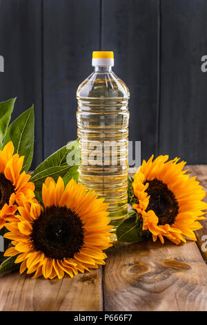 Dodsolnechnoe d'huile dans la bouteille, un bouquet de tournesols fleurs, gravé sur un arrière-plan. Produit naturel, style rustique. Copy space Banque D'Images