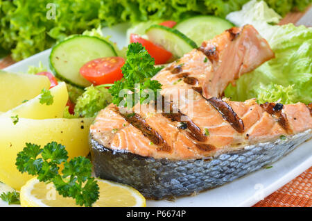 Pavé de saumon grillé avec des pommes de terre et salade Banque D'Images