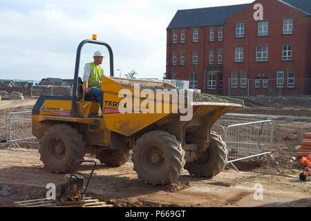 Workman conduire un camion dumper avec de la pierre concassée. Banque D'Images