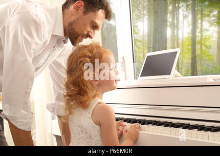 Un Père fille donnant des leçons de piano Banque D'Images