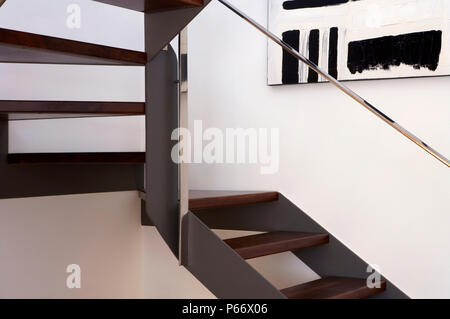 Escalier en bois avec la peinture sur le mur et la main courante en acier inoxydable Banque D'Images