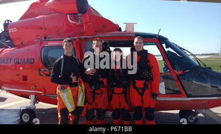 Maître de 3e classe Feske-Wood Nathan, un nageur de sauvetage, Maître de 1re classe Zachary Bowers, un mécanicien de vol, le lieutenant Quatroche Rachel, commandant de l'escadrille, et le lieutenant Addison Allen, le co-pilote de la Garde côtière canadienne, tous de l'Air Station Detroit, posent devant l'hélicoptère à l'Aéroport International d'Erie de Erie, Pennsylvanie, après une recherche et sauvetage du cas le 16 mai 2016. L'équipage a sauvé trois citzens canadiennes du lac Érié après le bateau de 42 pieds qu'ils étaient à bord s'est cassé en deux et capzised plus tôt le matin. (U.S. Photo de la Garde côtière par Air Station Detroit) Banque D'Images