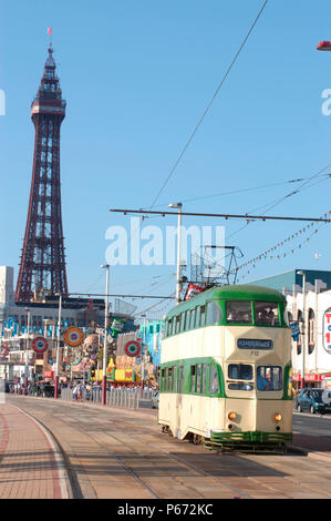 Une scène typique sur le front de mer de Blackpool comme l'un des trams du patrimoine du complexe traverse la promenade avec la célèbre Tour de Blackpool en arrière-plan. Banque D'Images