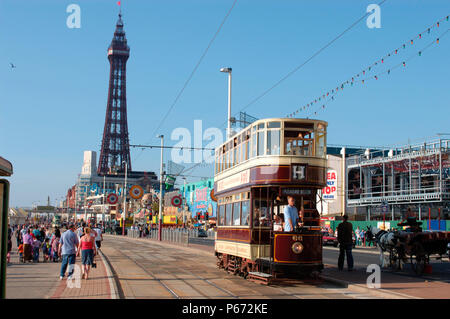 Une scène typique sur le front de mer de Blackpool comme l'un des trams du patrimoine du complexe traverse la promenade avec la célèbre Tour de Blackpool en arrière-plan. Banque D'Images