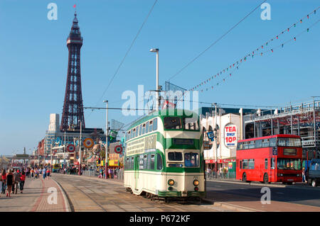 Une scène typique sur le front de mer de Blackpool comme l'un des trams du patrimoine du complexe traverse la promenade avec la célèbre Tour de Blackpool en arrière-plan. Banque D'Images