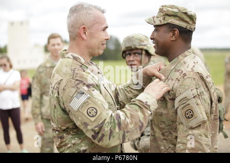 Le Sgt Major Santos Cavazos commande du 2e Bataillon, 325e Régiment d'infanterie aéroporté, 2e Brigade Combat Team, 82nd Airborne Division pins Sgt. 1re classe Emanuel murs avec un insigne de parachutiste maître après un saut au cours de la compétence Samedi Programme Jump (SPJP) à Fort Bragg, Caroline du Nord le 21 mai 2016. L'SPJP s'inspire de l'expérience, de compétence, et de la confiance des parachutistes, assurer le XVIII Airborne Corps et 82e Division aéroportée sont prêtes pour des missions d'intervention. (Photo par le Sgt. Tierney P. Curry)(1992) Banque D'Images