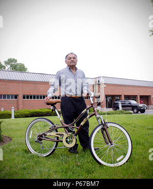 L'armée et la Force aérienne Exchange Service employé Fernando Castellon se distingue avec son vélo, qui lui ont été offerts par les membres de Joint Base Myer-Henderson Hall l'incendie et d'urgence, pour une photographie peut 10 en face de son lieu de travail, l'Express Shopette sur Fort Myer. Après la dernière piste s'Castellon, les pompiers ont pris des mesures et a fait don d'un nouveau vélo à Castellon, qui s'appuie sur le vélo pour se rendre au travail chaque jour sur Fort Myer. (Joint Base Myer-Henderson PAO Hall photo par Delonte Harrod) Banque D'Images