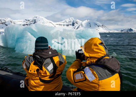 La Norvège, Svalbard, Spitzberg, Hornsund. Les touristes en zodiac près de grands icebergs flottants. Banque D'Images